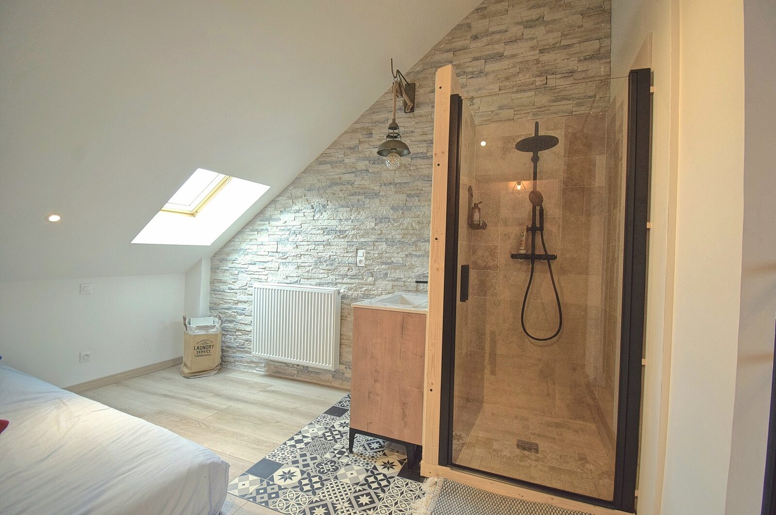 Salle de bain sous combles avec mur en pierre