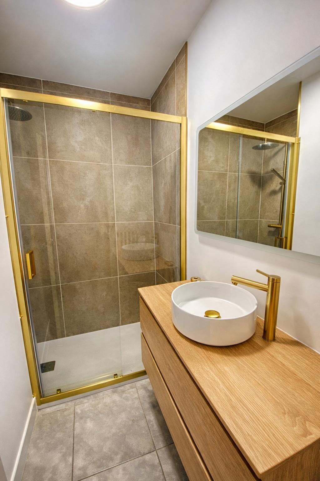 Salle de bain avec douche et robinetterie laiton